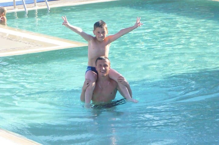 Leon Kercova on his brother Shemsi Kercova’s shoulders in a swimming pool.